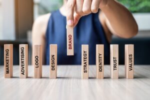 A person sitting at a desk placing wooden blocks with words on them down.