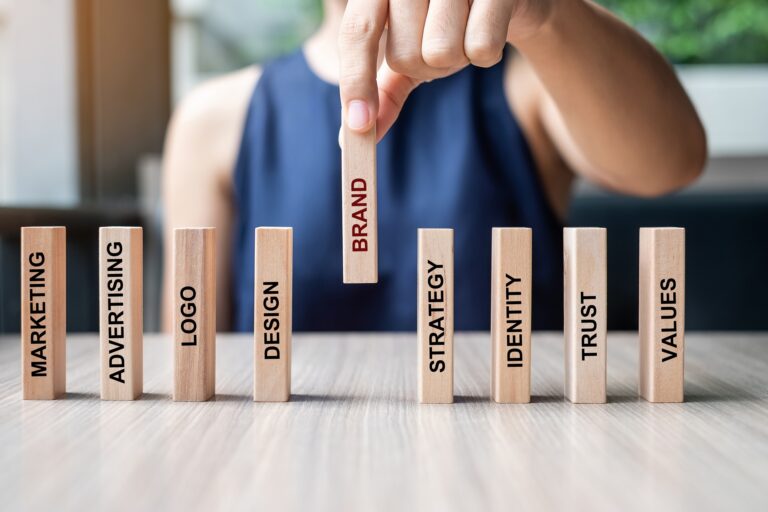 A person sitting at a desk placing wooden blocks with words on them down.