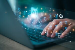 A person types on a laptop keyboard while glowing AI graphics float above their hands.