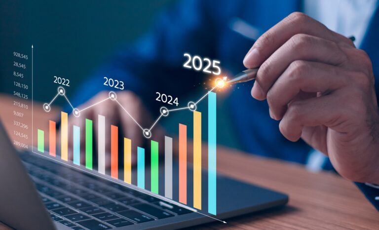 A man un front of a laptop pointing a pen at a graphic of a graph with years on it.
