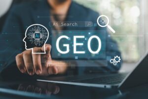 A person points at floating graphics above a laptop that says GEO.