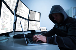 Image of a computer hacker who knows that most people don't know how to create a strong password.