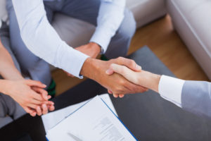 Image of an attorney and their client shaking hands after determining that new client discounts are a bad idea.